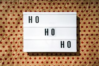 A light box with the words 'Ho Ho Ho' on, on top of a red and brown polka dot background.