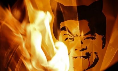 Protesters burn an illustration of Hong Kong Chief Executive Leung Chun-ying as the devil during massive demonstrations Sunday calling for Leung's resignation.