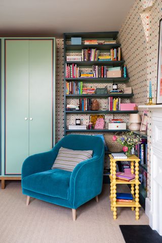 Blue velvet armchair in front of bookshelves