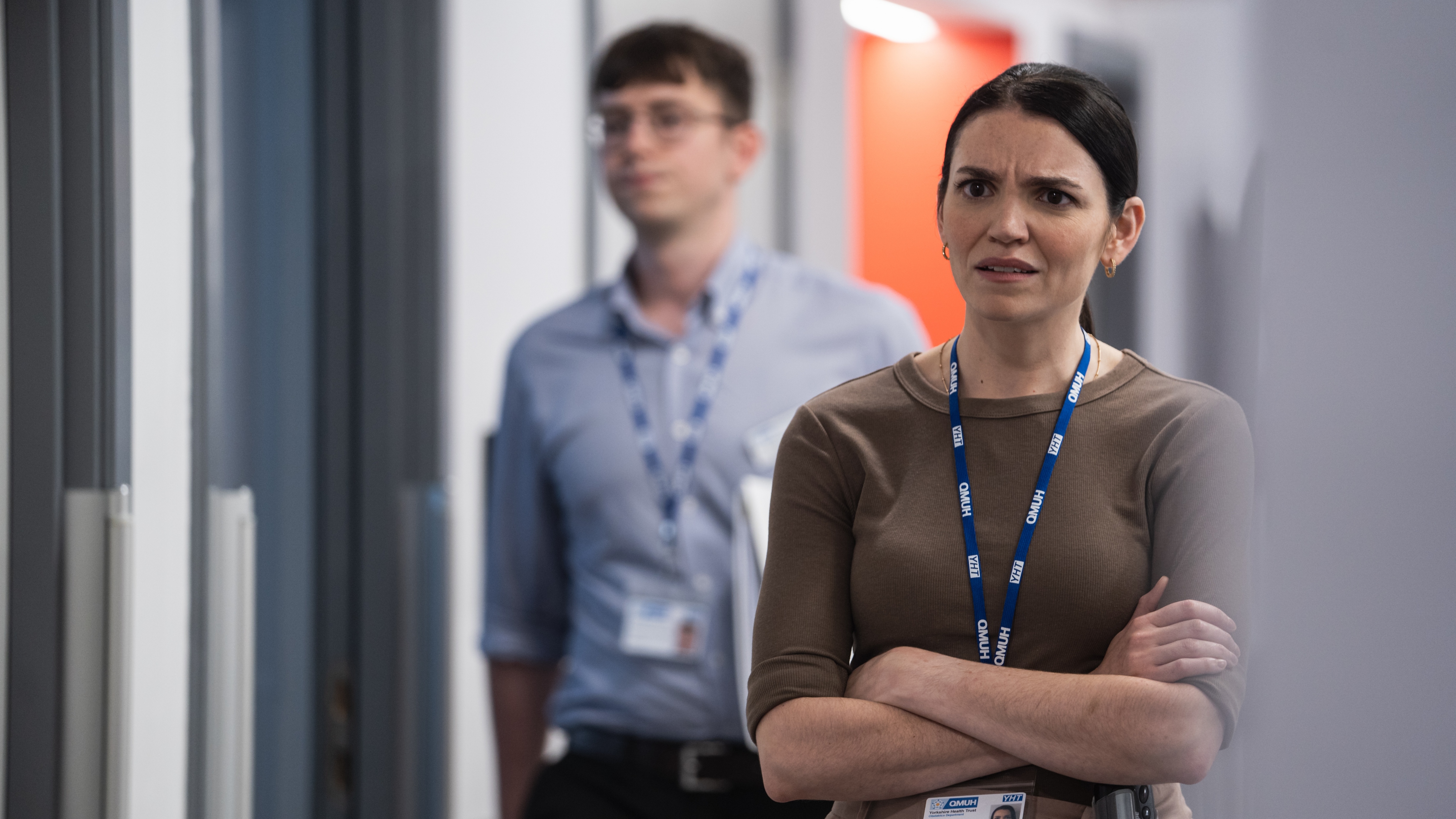 Pictured: SELIN HIZLI as DR Sophia Hernandez looking cross with her arms crossed while standing in a hospital corridor.
