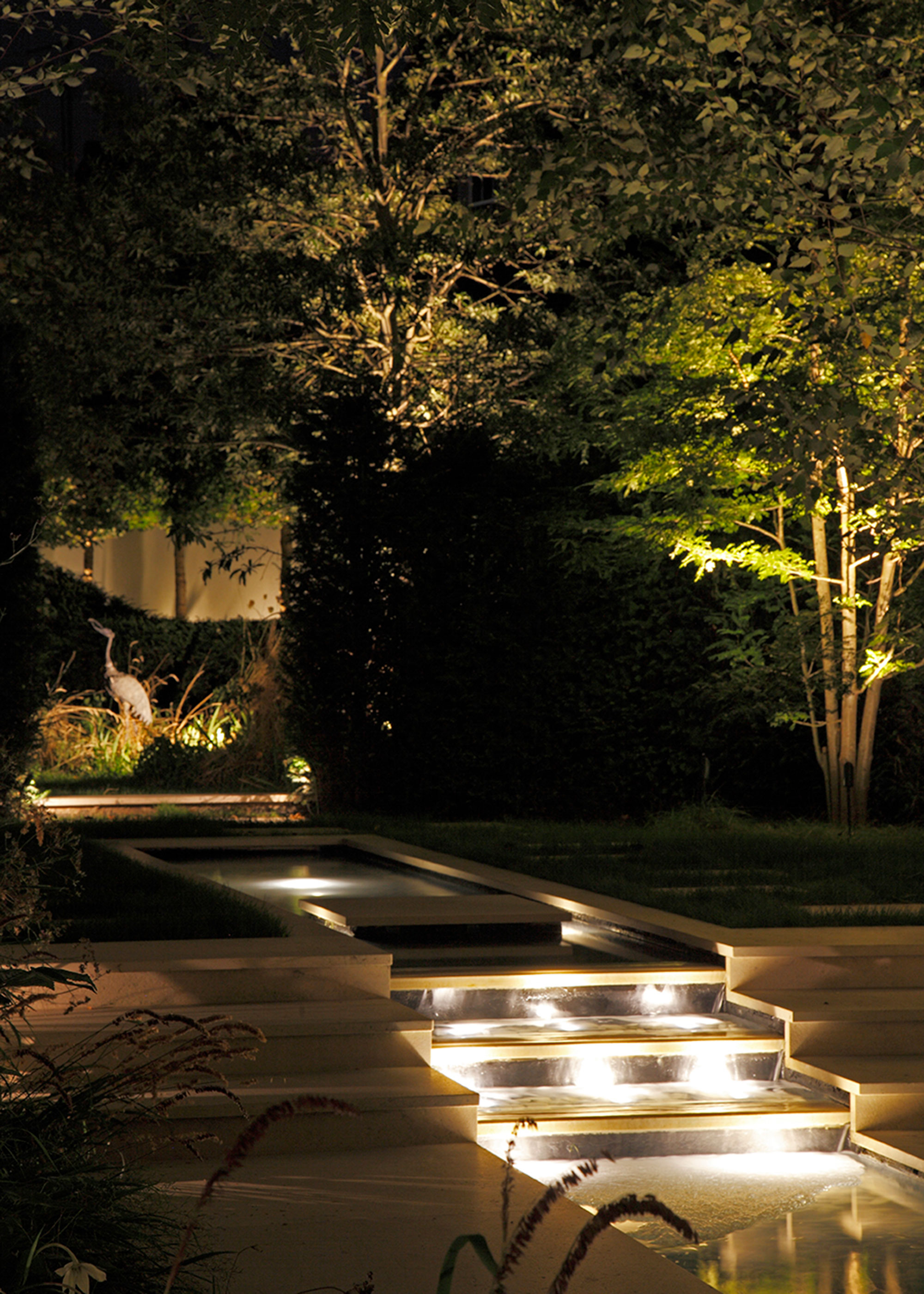 stepped water feature with exterior lighting and tree lighting
