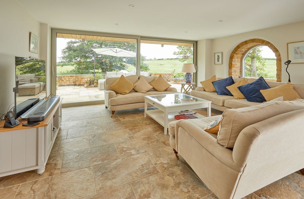Living room with sliding panel doors which lead to the outside terrace and shows the garden features