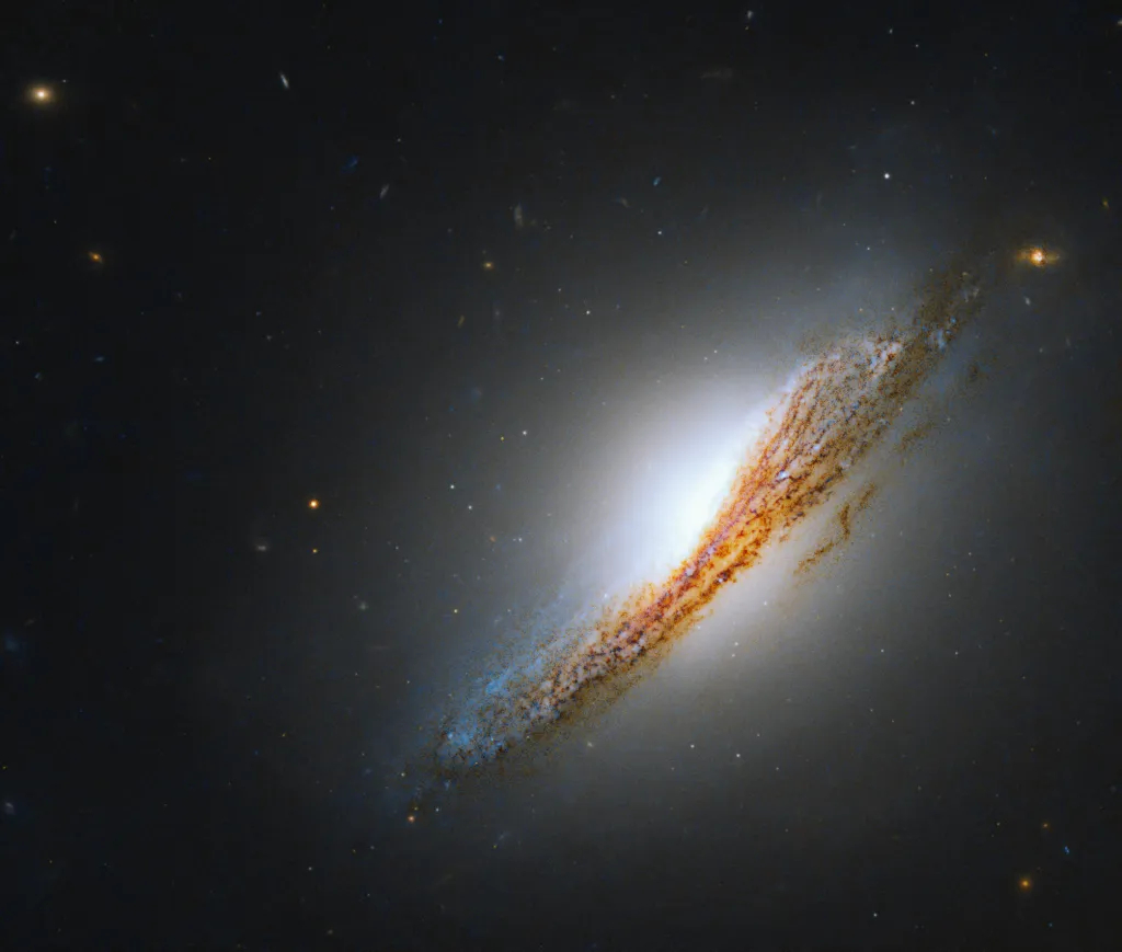 A striking orange and blue streak fills this new image from NASA's Hubble Space Telescope. Hubble’s visible and infrared capabilities captured this edge-on view of lenticular galaxy NGC 612.