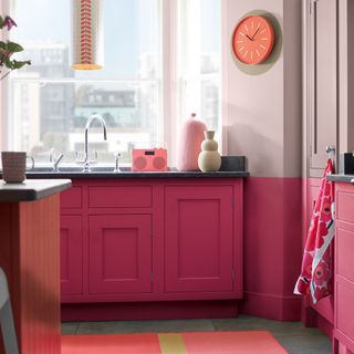 kitchen room with pink cabinets and clock on wall with glass window