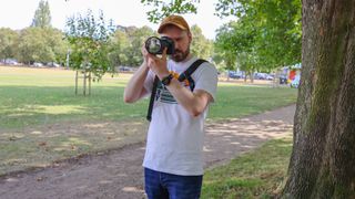 A man wearing the BlackRapid Blackline I Right Sling in a park