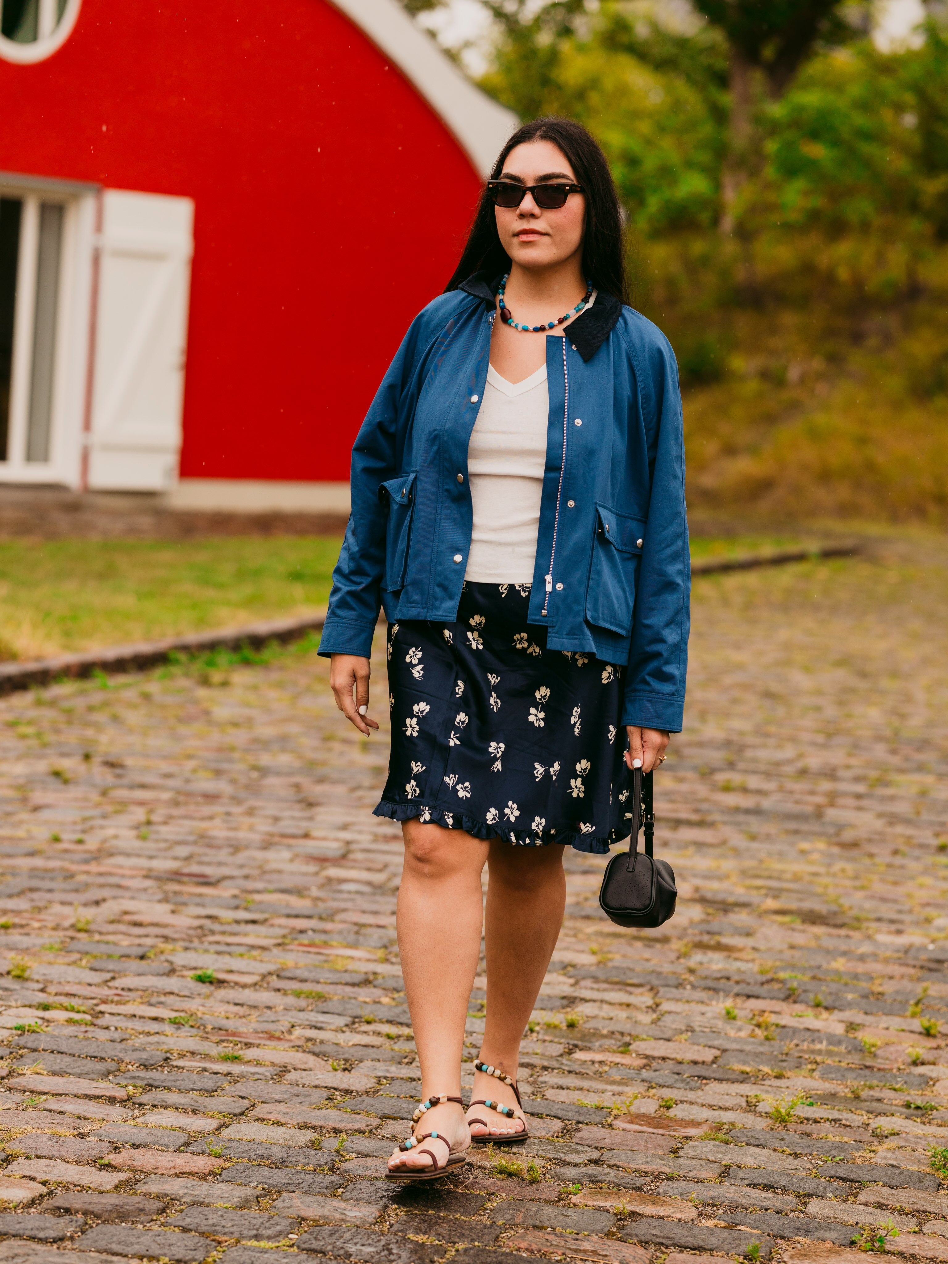Woman in a barn jacket, slip skirt, white tank and sandals