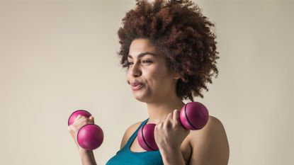 Image shows woman resistance training with weights