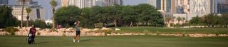 A golfer hits a shot at the Qatar Masters
