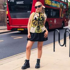 Woman wearing Dr Martens boots with a skirt and top on a London street