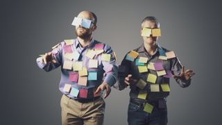 Two men covered in post-it notes act like zombies.