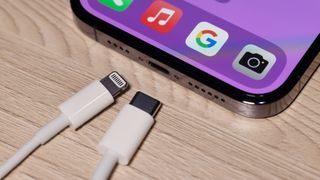 En Lightning-laddare och USB-C-laddare bredvid en iPhone 14.