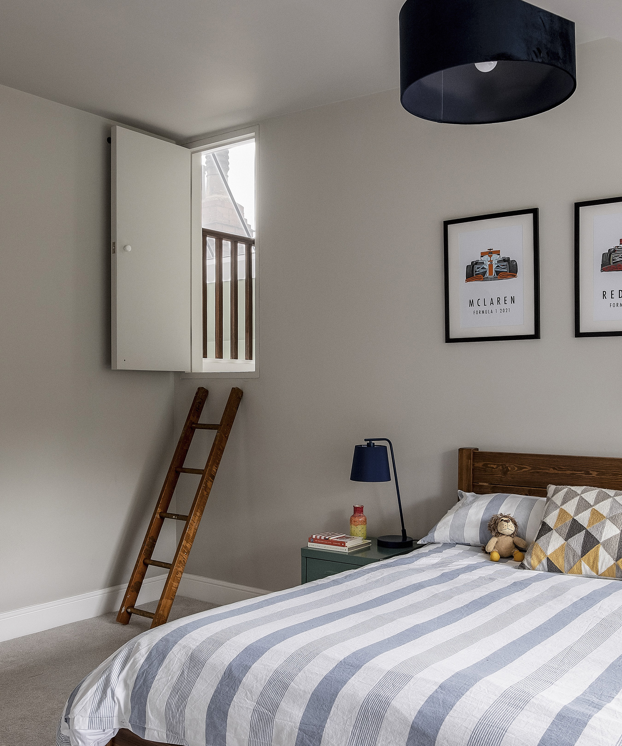 A child's bedroom with ladder up to a secret playroom nook