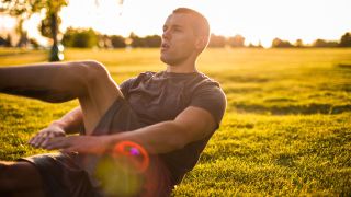 Man peforming lower abs exercise in park