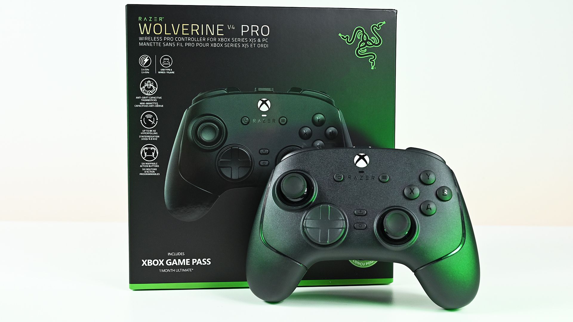 Front view of the black wireless Razer Wolverine controller standing upright in front of its green and black retail packaging box.