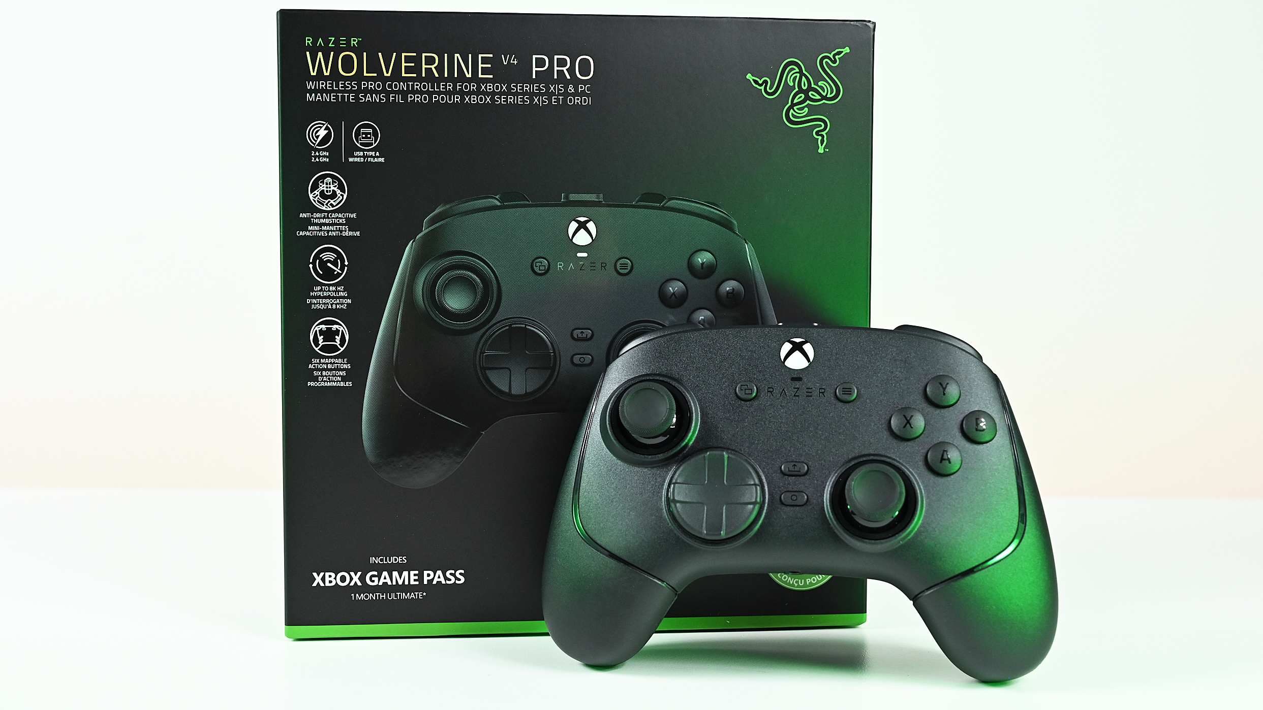 Front view of the black wireless Razer Wolverine controller standing upright in front of its green and black retail packaging box.