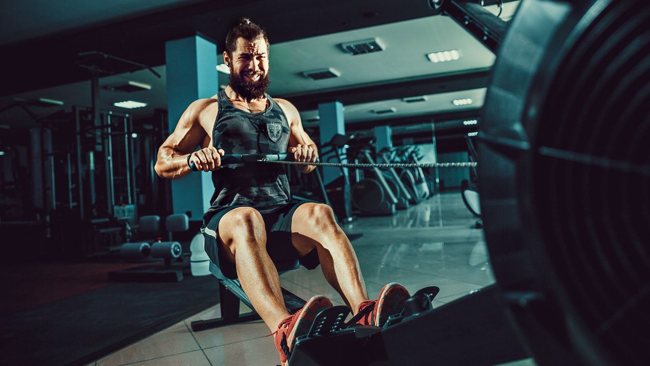 Man doing a workout on a rowing machine at the gym