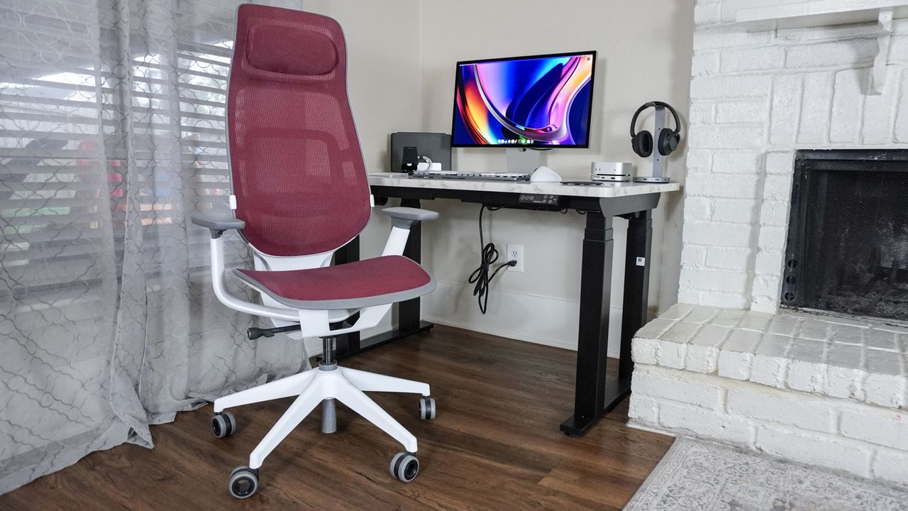 A wide shot of the Steelcase Karman High Back in front of a desk