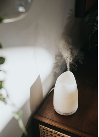 A simple white oil diffuser spritzing a light mist of water.