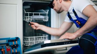Man fixing dishwasher making a grinding noise