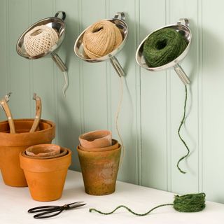 green wall with storage pots and twine dispensers