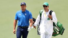 Bryson DeChambeau and his caddie, Greg Bodine walk along at The Masters in 2025