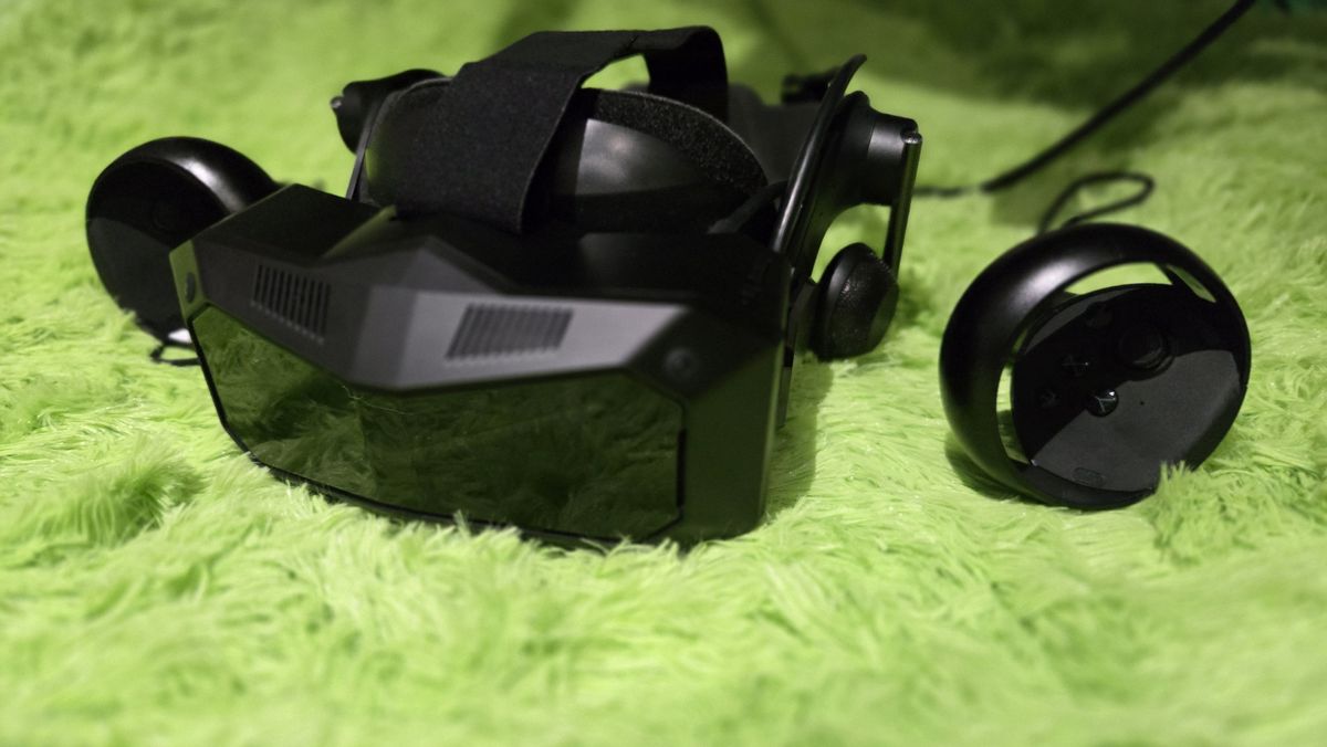 A Pimax Crystal Super virtual reality headset on a green background.