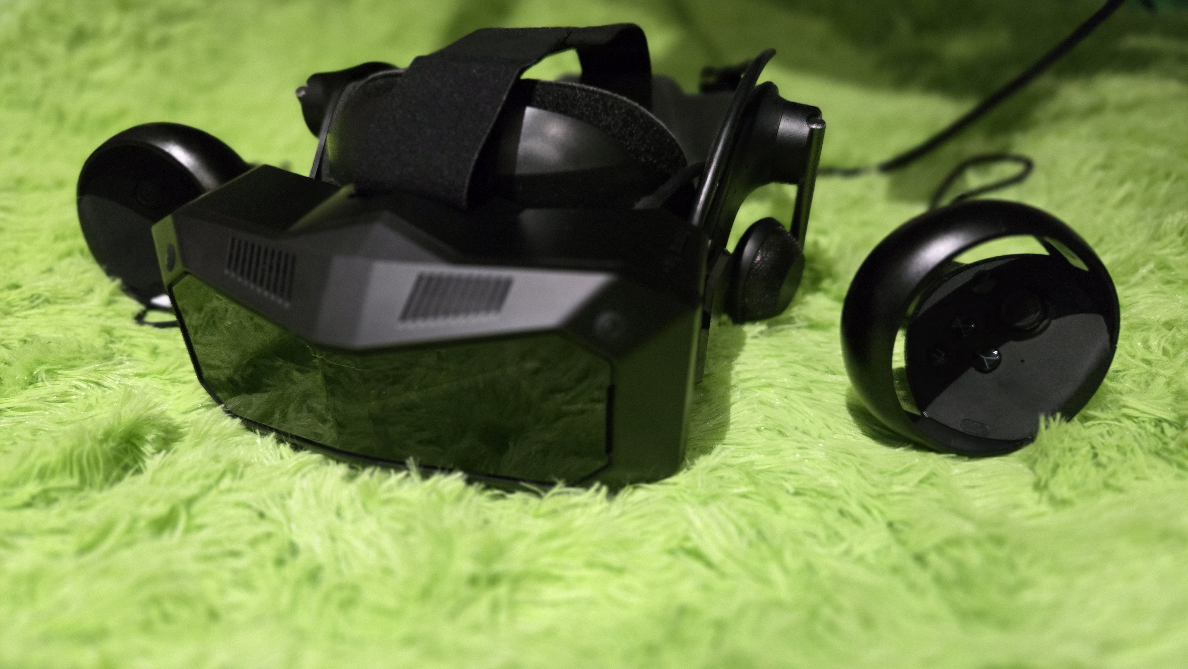 A Pimax Crystal Super virtual reality headset on a green background.