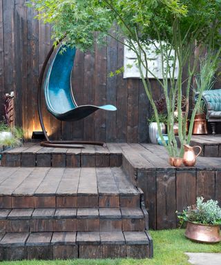 wooden decking with modern chair and tree
