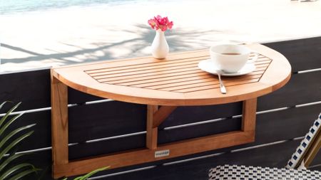 Outdoor fold down table mounted to the wall of a breezy backyard patio overlooking the ocean