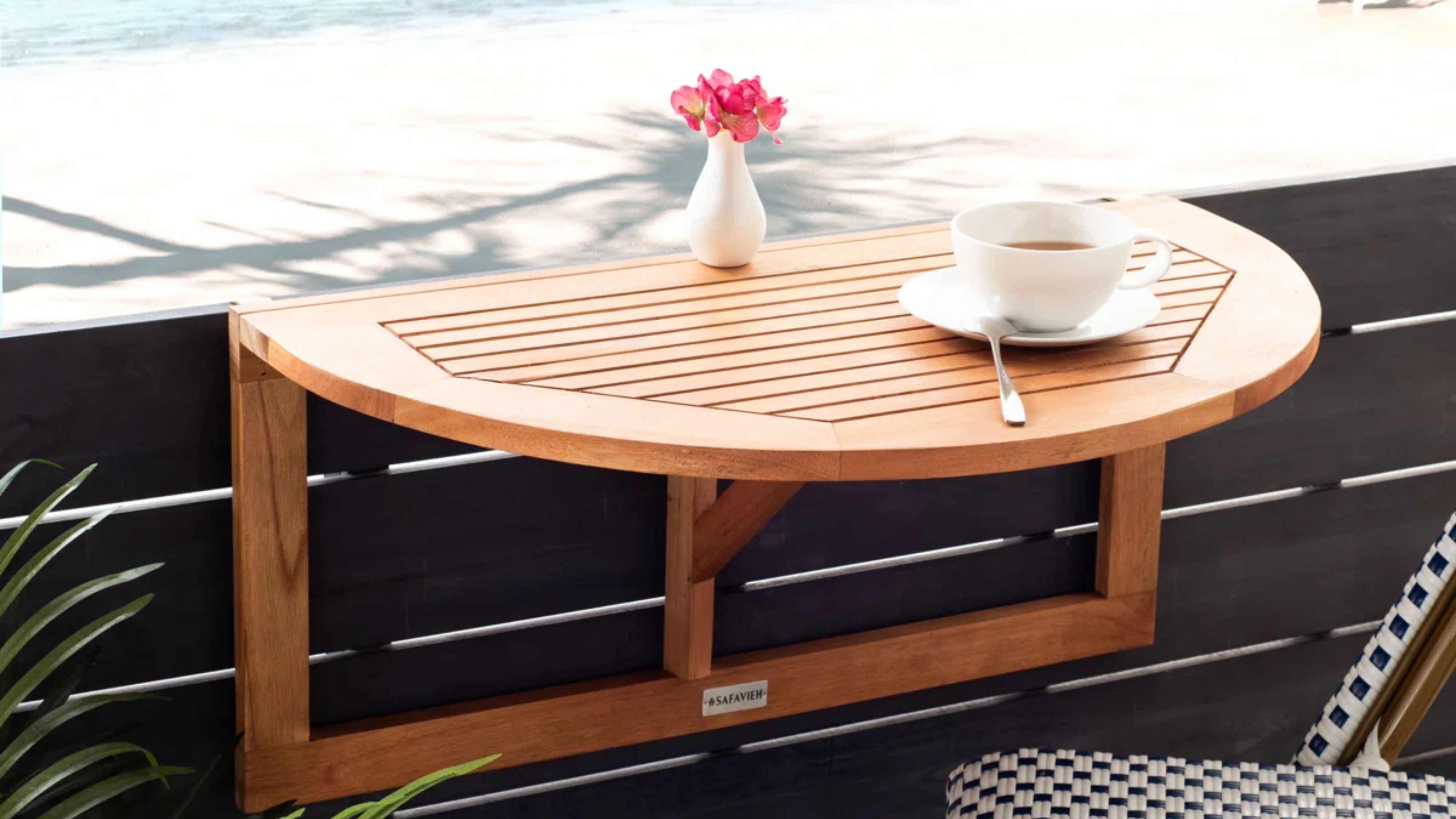 Outdoor fold down table mounted to the wall of a breezy backyard patio overlooking the ocean
