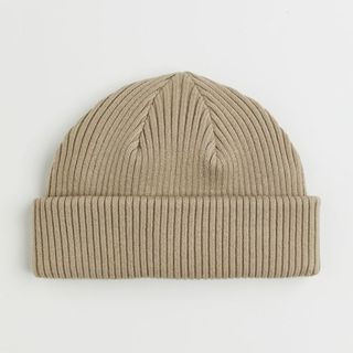 A product image of a beige rib-knit beanie