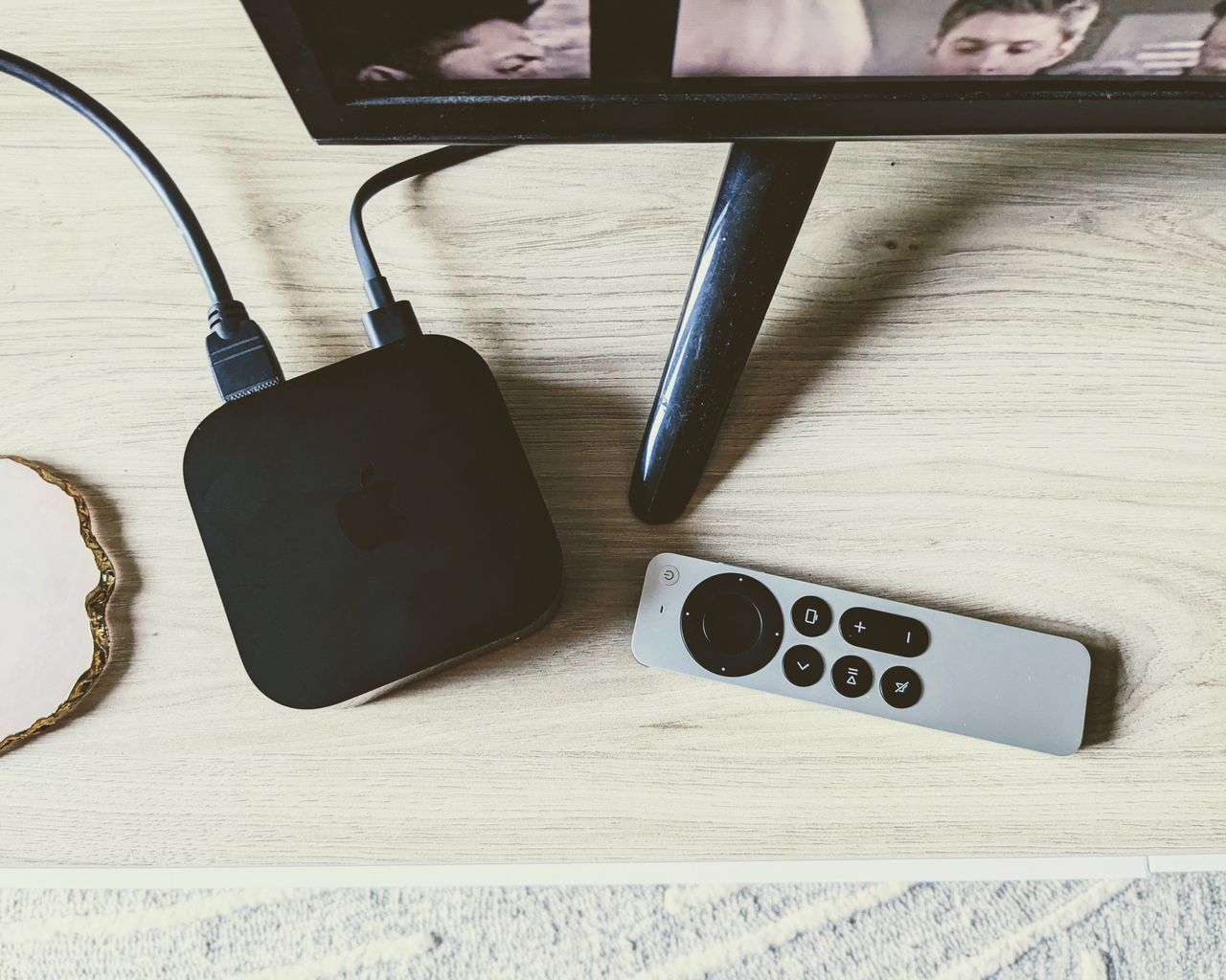 Apple TV 4K and remote viewed from above on TV unit in writer&#039;s home