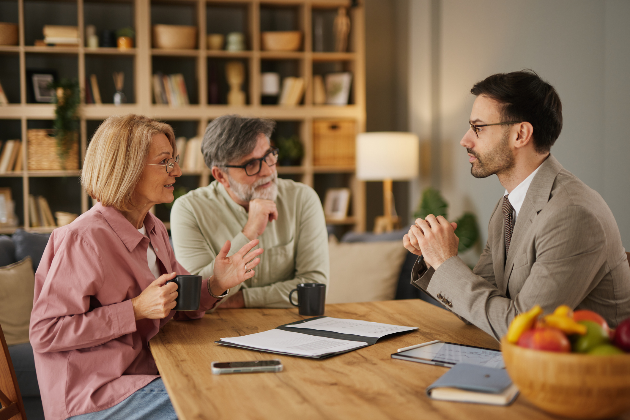 Senior couple discussing personal finances with financial advisor at home 