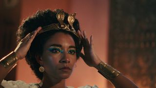 Adele James putting her crown on in Queen Cleopatra