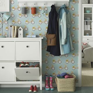 room with shoe cupboard and blue bicycle wallpaper