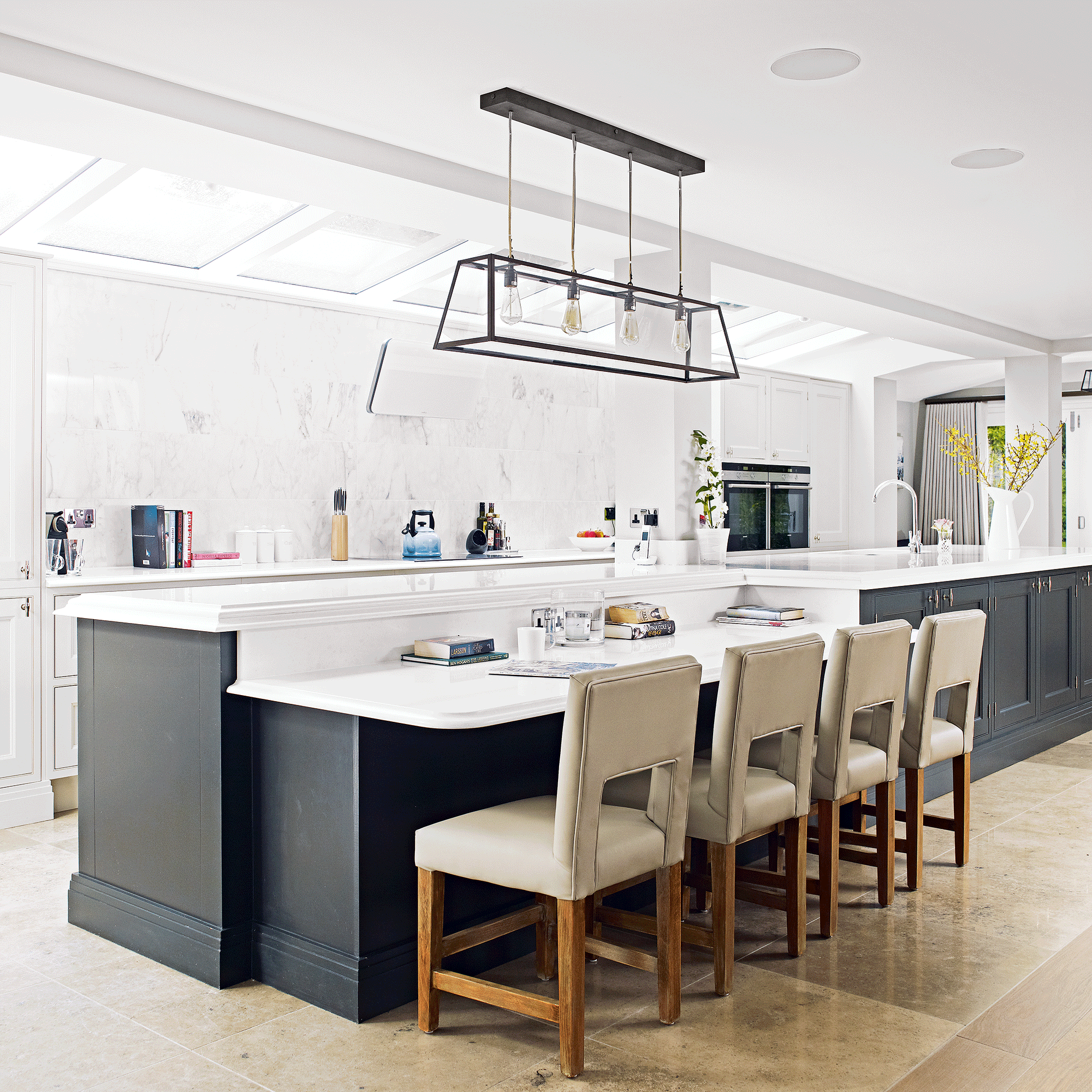 White kitchen with long kitchen island and chairs
