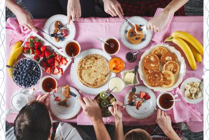 A breakfast table covered in an array of pancakes and pancake toppings