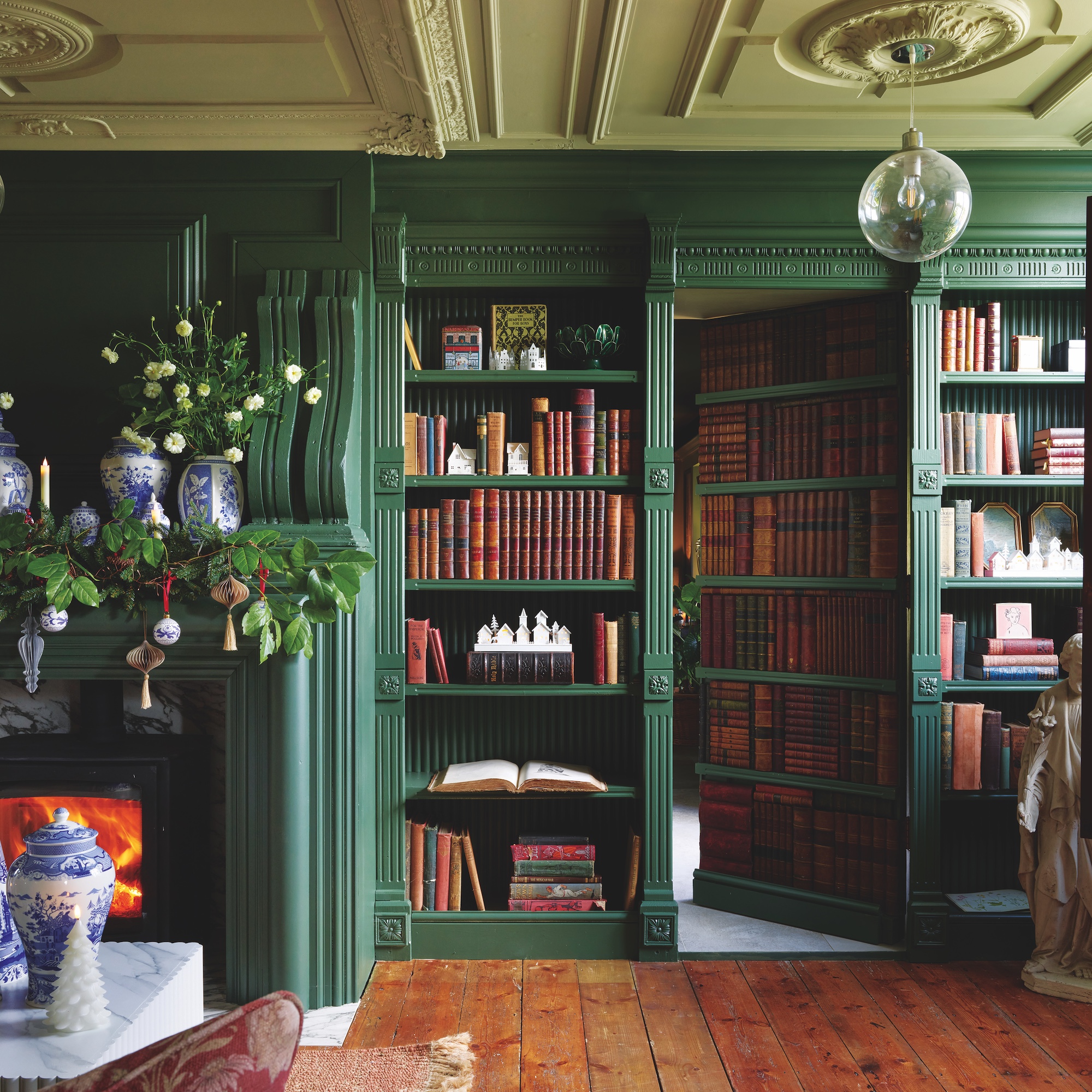 dark green library room with bookshelves with secret door to adjacent room