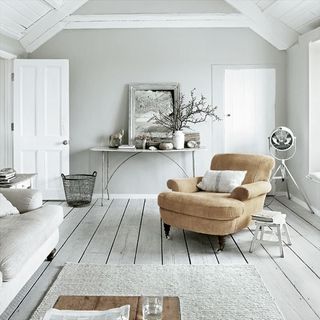 living room with white walls and armchair with white door