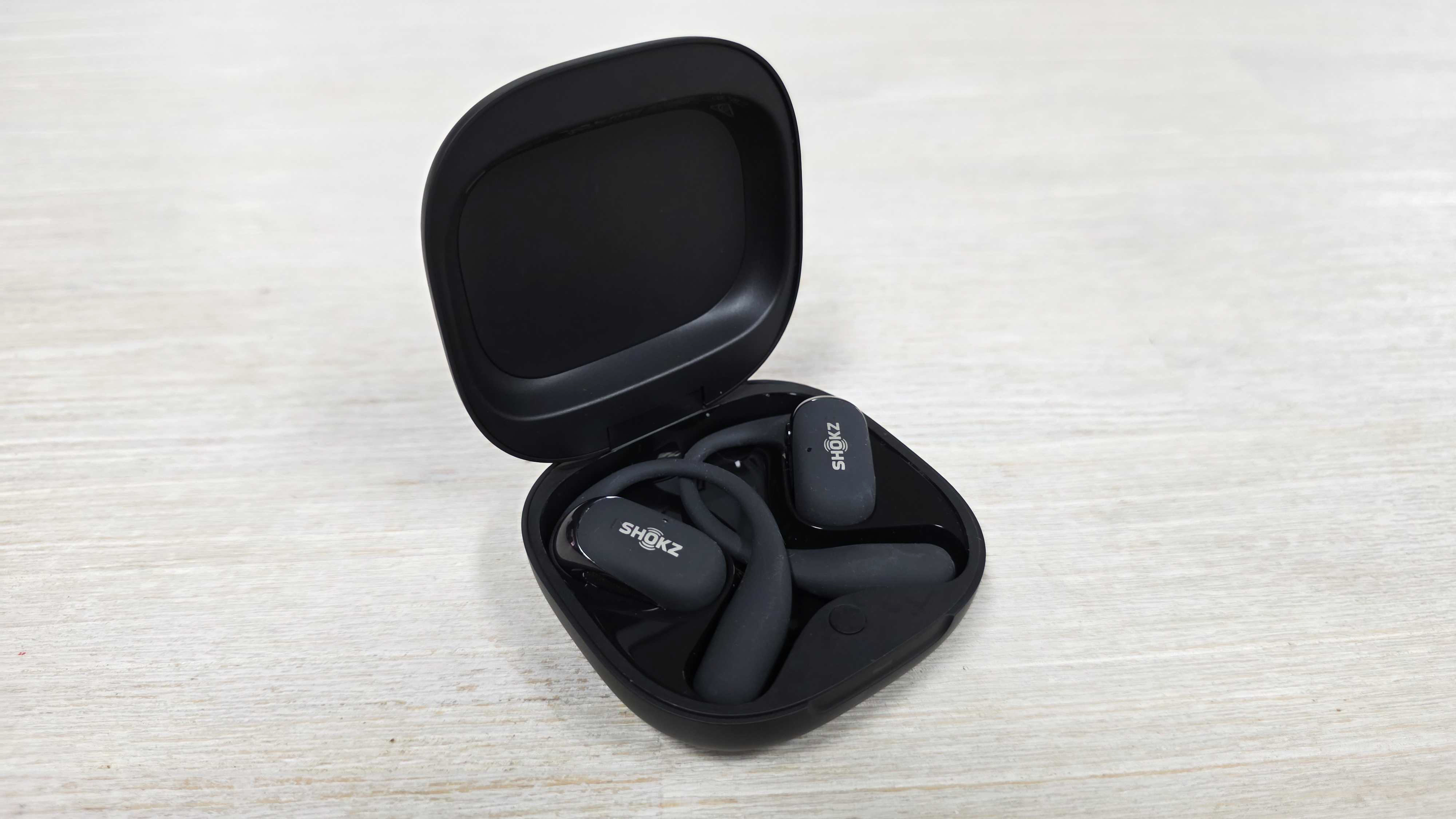 Shokz OpenFit 2 Plus in open charging case on table