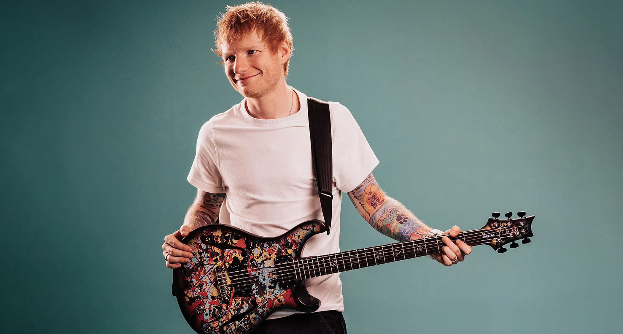 Ed Sheeran with his new PRS SE Ed Sheeran Cosmic Splash Hollowbody Baritone Piezo, a limited edition signature guitar featuring his own original artwork.