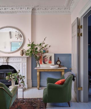 Pink living room with green sofa and armchair