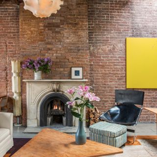 living room with exposed brick walls and white marble fireplace