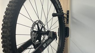 Bike wheel attached to hook on wall