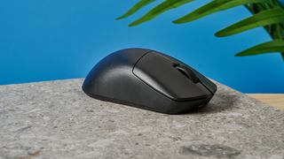 A black Lemokey G1 wireless gaming mouse sitting on a marble slab