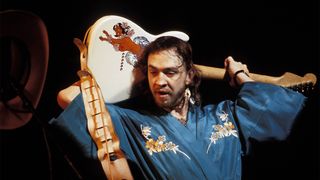 American musician, guitarist and singer Stevie Ray Vaughan (1954-1990) performs live on stage playing a Fender Stratocaster guitar behind his head during a concert performance in the United States in 1985.