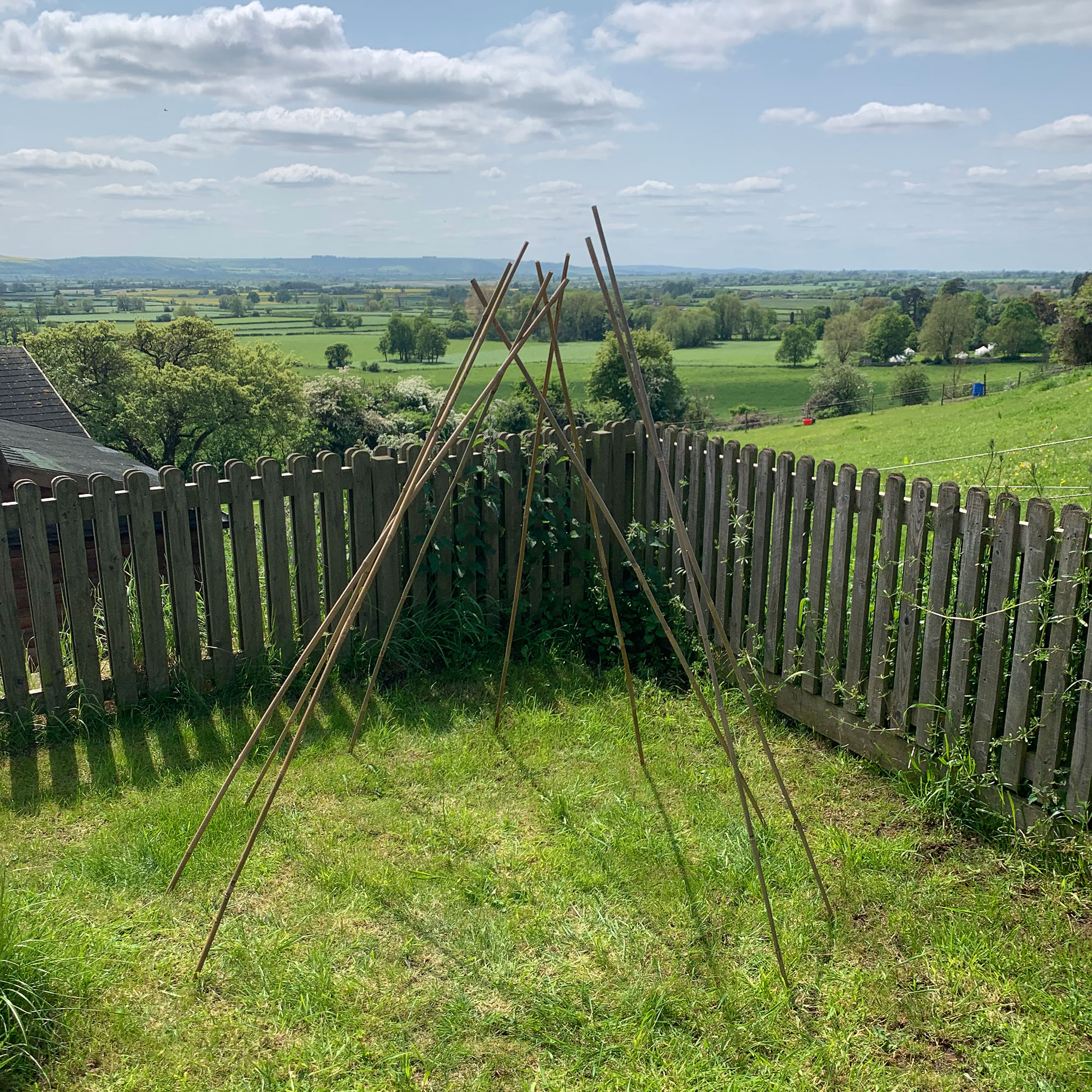 Wooden teepee structure in country garden