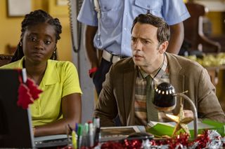 Naomi (Shantol Jackson) and Neville (Ralf Little) sit at a desk in the police station looking at the computer