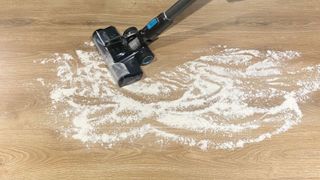 The Hoover ONEPWR vacuuming flour and sugar from a linoleum floor