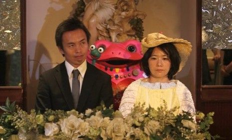 A Japanese couple sits during their divorce ceremony Sunday: After celebrating with friends and smashing their rings the couple will file for divorce.